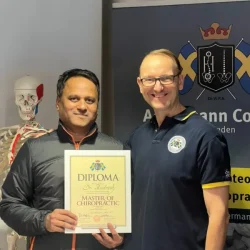 Dr. Rudresh holding his authentic Europe-Certified Chiropractic Master Diploma from Ackermann College, Sweden, serving patients in Bangalore.